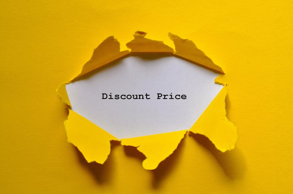 A bright yellow paper background with a large tear revealing a white sheet of paper beneath. The torn edges are jagged and curled, creating a textured, three-dimensional effect. On the exposed white paper, the words 'Discount Price' are printed in black, typewritten-style font. The overall scene suggests a visual metaphor for revealing savings or cost reductions, relevant in contexts such as alternative rubbish removal or private waste handling services offered by waste clearance companies like wasteclearancesouthkensington.co.uk. The lighting is even, highlighting the torn paper’s rough edges and the crisp contrast between the yellow and white surfaces, emphasizing the notion of uncovering or revealing value discreetly and professionally.